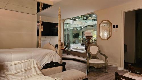 a bedroom with a bed and a chair and a tub at Hotel Oasis Lac St-Louis in Salaberry de Valleyfield