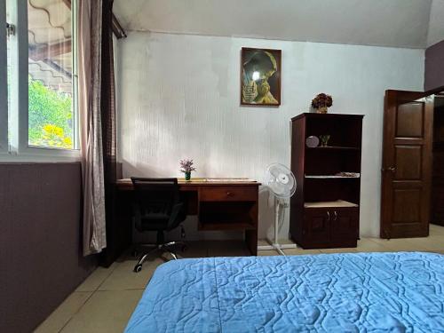a bedroom with a bed and a desk and a chair at El encanto tropical, a minutos del IRTRA in Ajaxá