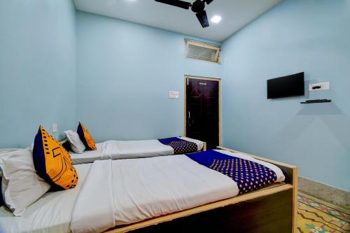 a bedroom with two beds and a flat screen tv at Hotel O Gajraj in Guwahati
