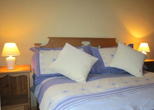 a bedroom with a bed with blue and white pillows at Gorteen in Caherdaniel