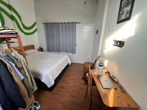a small bedroom with a bed and a table at Black and Putih Stay in Munggu