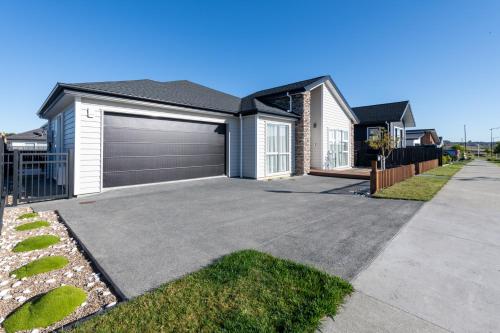 a house with a garage and a driveway at Luxurystay - Coastal Suite Wainui - Brand New in Silverdale