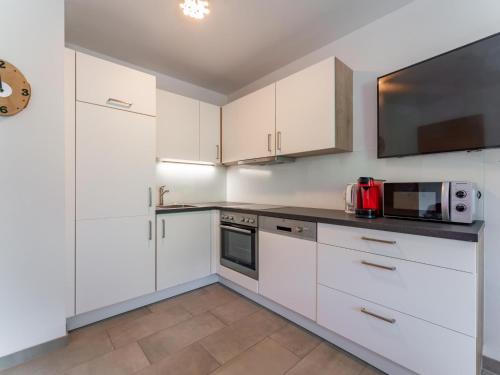 a kitchen with white cabinets and a microwave at Ferdinand B in Hirnreit