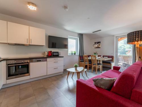 a living room with a red couch and a kitchen at Ferdinand in Hirnreit