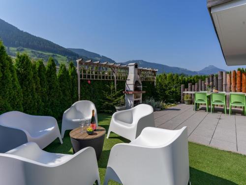 a patio with white chairs and tables and a grill at Ferdinand in Hirnreit