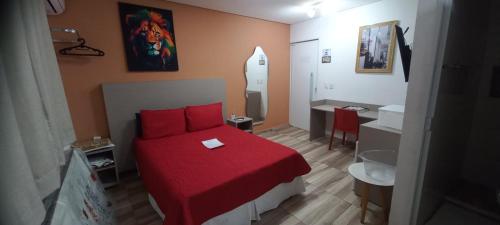 a bedroom with a red bed and a bathroom at Loft Portal Beach 01 in Recife