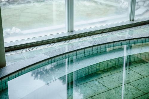 a glass window with a reflection of a building at KAMENOI HOTEL Kochi in Ino