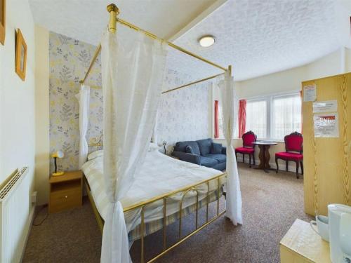 a bedroom with a canopy bed and a living room at Northcote Hotel in Bridlington