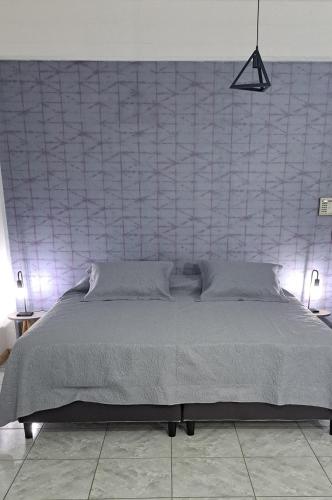 a bedroom with a large bed with a wall at Monoambiente Eldorado II in Eldorado