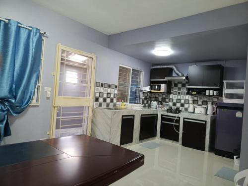 a kitchen with a wooden table in a room at Private Room in a Shared Homestay in Thalang