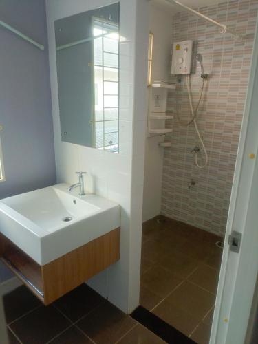 a bathroom with a sink and a shower at Private Room in a Shared Homestay in Thalang