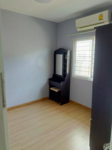 an empty living room with a tv and a window at Private Room in a Shared Homestay in Thalang