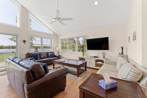 a living room with a couch and a tv at Expansive Lakefront Home with Private Dock in Grand Junction