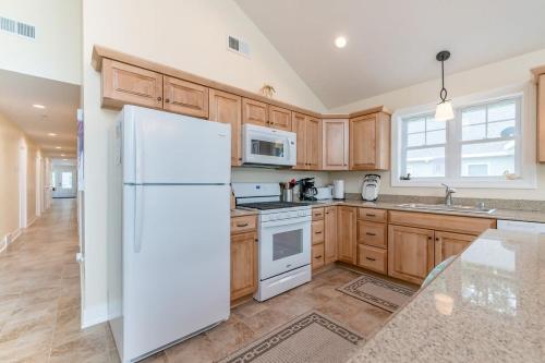 a kitchen with wooden cabinets and a white refrigerator at Expansive Lakefront Home with Private Dock in Grand Junction