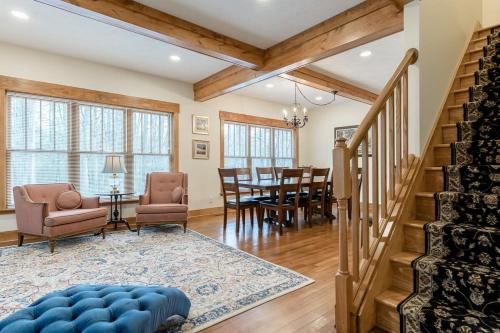 a living room with a staircase and a dining room at Snug Cabin with Hiking Trail and Private Lake Access in Grand Junction