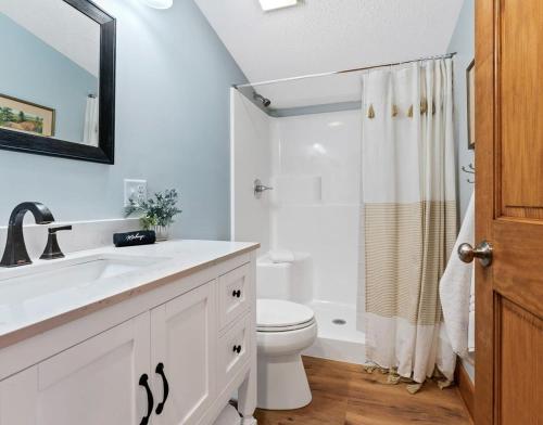 a white bathroom with a sink and a toilet at Snug Cabin with Hiking Trail and Private Lake Access in Grand Junction