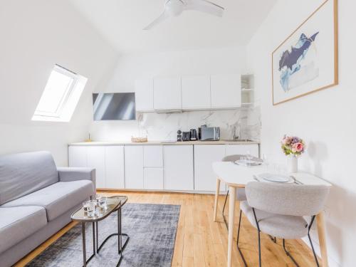 un salon blanc avec un canapé et une table dans l'établissement Cosy apartment - 1BR 4P - Champs Elysée, à Paris