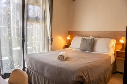 a bedroom with a bed with a hat on it at Hotel Boutique El Parque in Concepción