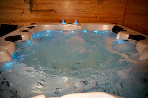 a jacuzzi tub with blue candles in it at Suite, Hammam, Sauna, et Jacuzzi in Sedan