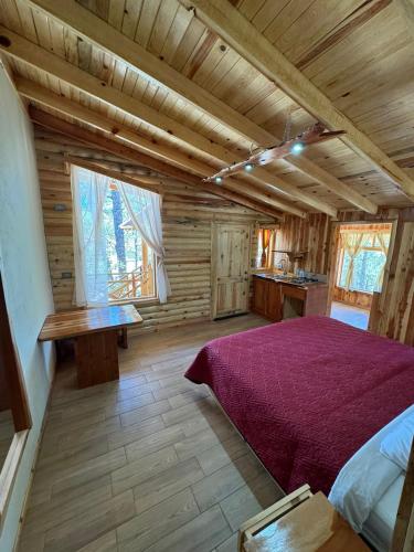 a bedroom with a bed in a log cabin at Grand Mountain Cabañas Creel in Creel