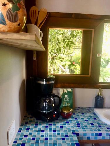 a kitchen counter with a coffee maker and a window at Quirama Lodge in Carmen de Viboral