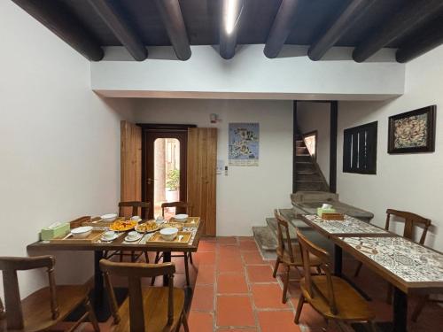 a dining room with tables and chairs and a staircase at 八八金歐王金城洋樓古厝民宿 in Jinsha