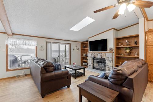 a living room with two leather couches and a tv at Lakefront Retreat in a Serene Country Setting in Pullman