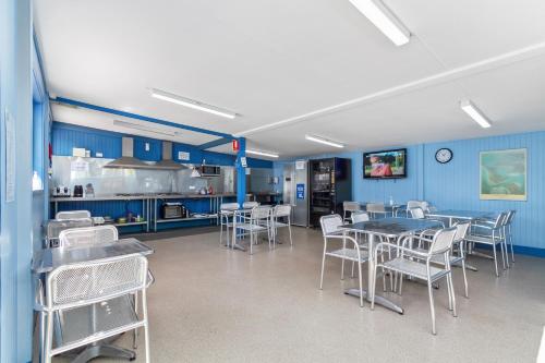 a kitchen with blue walls and tables and chairs at Waters Edge Holiday Park in Lakes Entrance