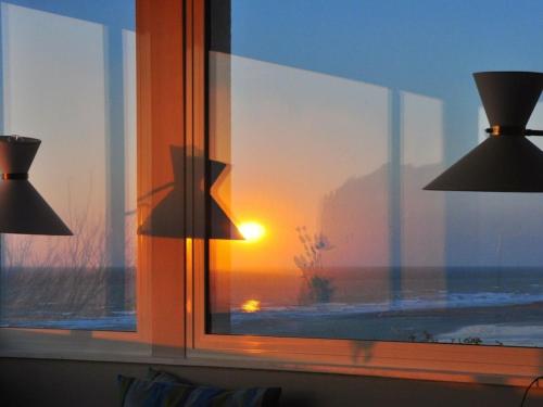 a window with a view of the sunset at Holiday home for 8 people in Veulettes-sur-Mer