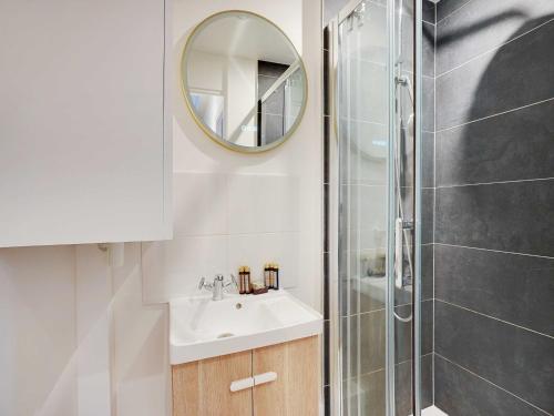 une salle de bain avec un lavabo et une douche avec un miroir dans l'établissement Beautiful Apartment - 6P-Auteuil Saint Cloud, à Paris