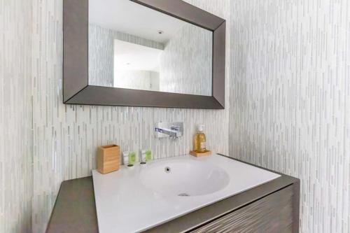 une salle de bain avec un lavabo blanc et un miroir dans l'établissement Modern apartment - 1BR 4P - Plaine-Monceau, à Paris