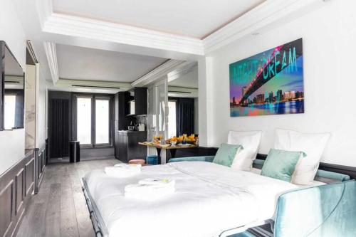 une chambre avec un grand lit blanc et une cuisine dans l'établissement Modern apartment - 1BR 4P - Plaine-Monceau, à Paris