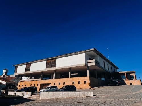 a building with cars parked in a parking lot at Hotel Fortaleza de Almeida by ASITE Hotels in Almeida