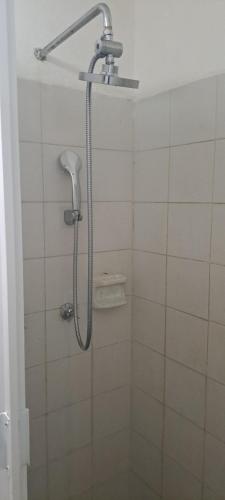 a shower with a shower head in a bathroom at Hostal Mari sabina in Bucerías