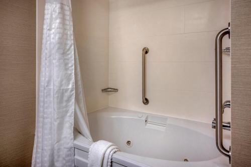 a bathroom with a bath tub with a shower curtain at Comfort Suites near Penn State - State College, PA in State College