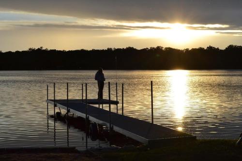 a person standing on a dock on a lake at Open Concept Lakefront Home with Rec Room and Fire Pit in Grand Junction