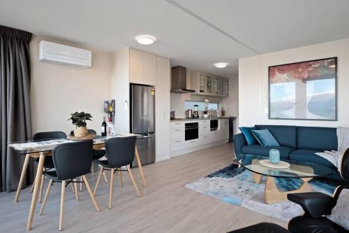 un soggiorno con un divano blu e un tavolo di Remarkable VIEWS 2 Bedrooms & BIG DECK a Queenstown