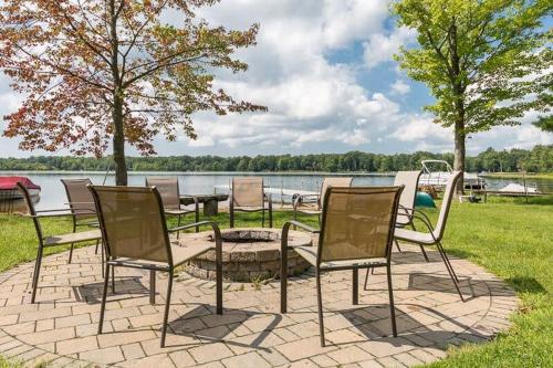 a group of chairs sitting around a fire pit next to a lake at Lakefront Tranquility Spacious Retreat Sleeps 14 in Grand Junction
