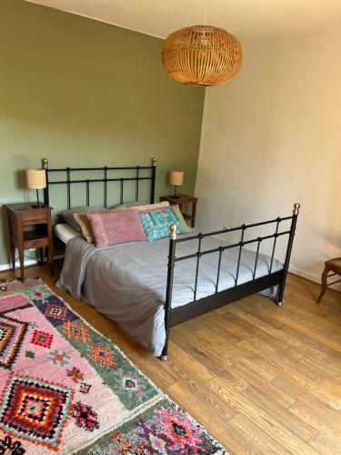 une chambre avec un lit et un tapis au sol dans l'établissement Maison de charme dans le vieux Marly, à Marly-le-Roi