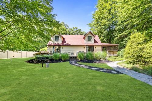 a house with a red roof on a green yard at Scenic and Stunning Lakefront Home with Large Yard in Grand Junction