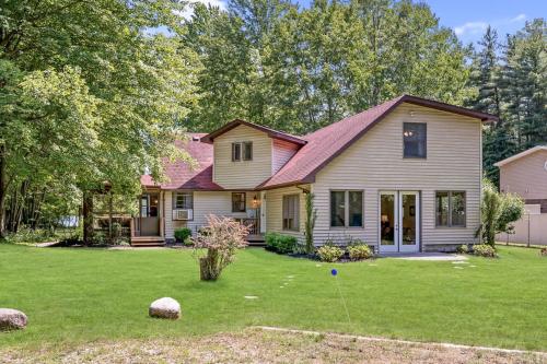a house with a yard with green grass at Scenic and Stunning Lakefront Home with Large Yard in Grand Junction