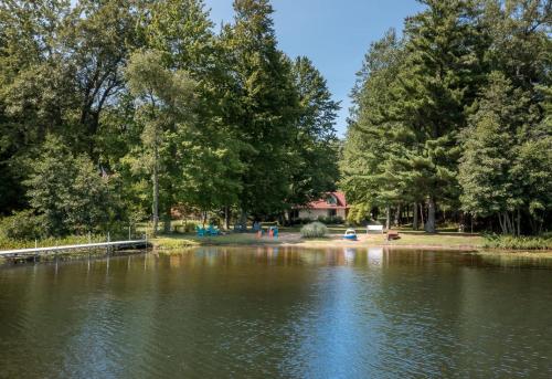 a view of a lake with trees in the background at Scenic and Stunning Lakefront Home with Large Yard in Grand Junction