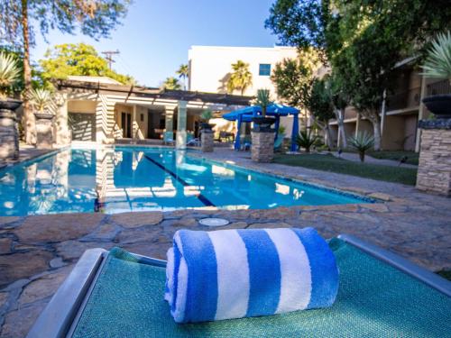a blue and white towel sitting on a raft in a swimming pool at Hotel Araiza Mexicali in Mexicali