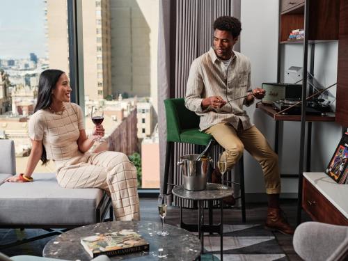 a man and a woman sitting in a living room at Le Meridien Melbourne in Melbourne