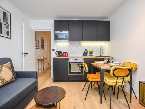 Il dispose d'une cuisine et d'un salon avec un canapé et une table. dans l'établissement Welcoming apartment - 1BR 4P - Arc de Triomphe, à Paris