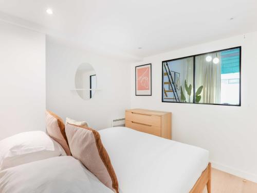 une chambre blanche avec un lit et un miroir dans l'établissement Cosy apartment - 1BR 4P - Passy Tour Eiffel, à Paris