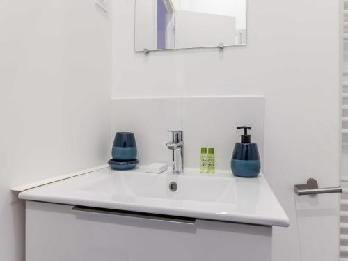 un lavabo de salle de bain blanc avec des objets bleus dessus dans l'établissement Cosy apartment - 1BR 4P - Passy Tour Eiffel, à Paris