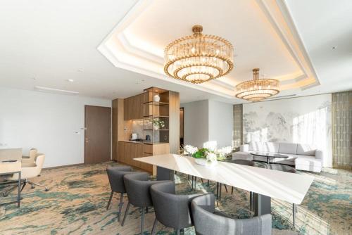 a dining room and living room with a table and chairs at Stanford hotel Andong in Andong