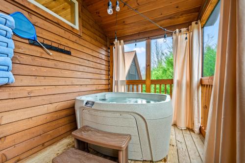 a jacuzzi tub in a wooden room with a window at Sona Cabins in Gatlinburg
