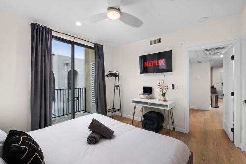 a bedroom with a bed and a tv on the wall at King Bed EVCharger Sleeps 8 Balcony Laundry in San Diego
